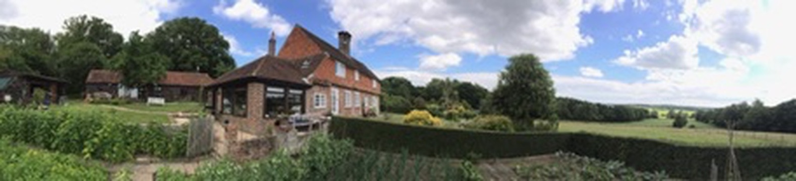 Panoramic view of Lodge Farmhouse and its surrounding gardens and countryside